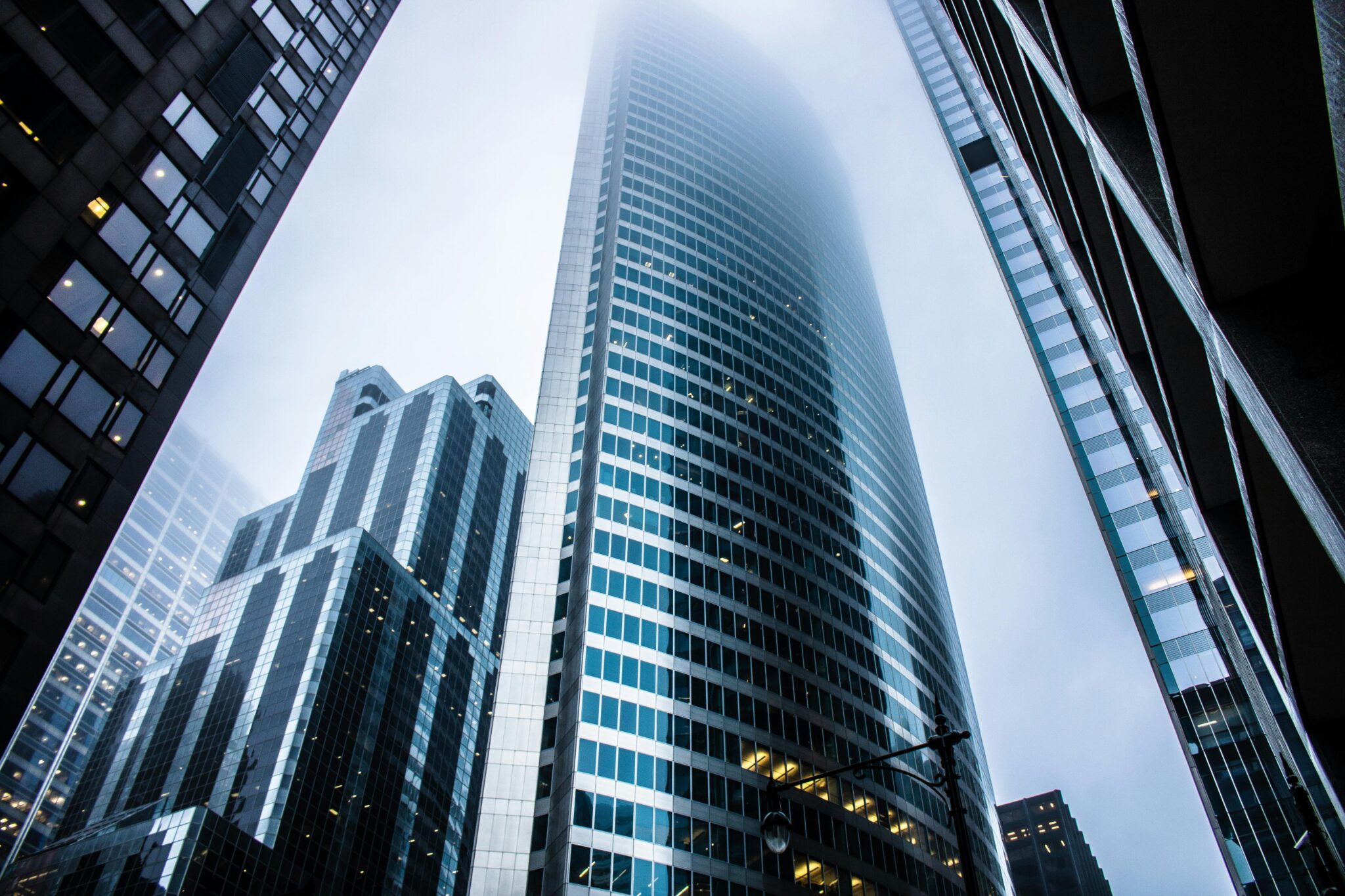 Obligaciones Legales del Q1: Amable Recordatorio para las SAS en Colombia Dramatic view of modern skyscrapers shrouded in fog in an urban cityscape.