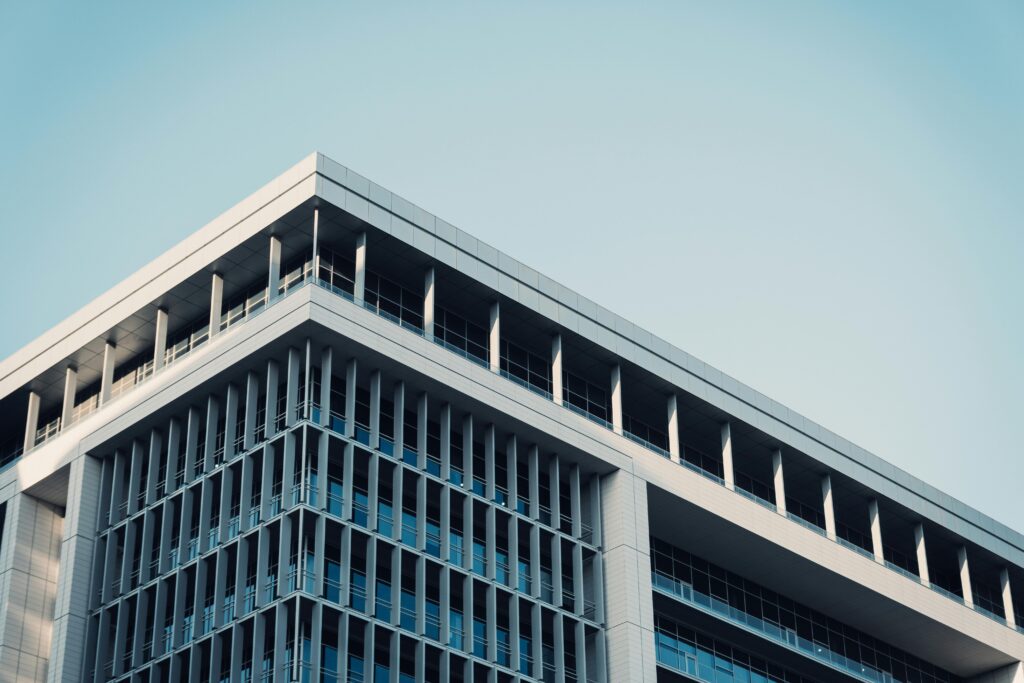 Contemporary office building with a futuristic glass facade reflecting the sky.